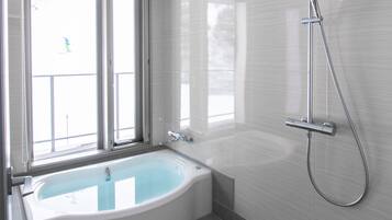 A modern bathroom with a freestanding bathtub, a showerhead, and a window providing natural light.