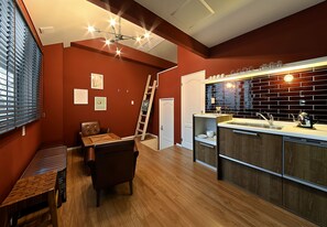 Modern kitchen with sink, stainless steel faucet, and small island with tea pot.