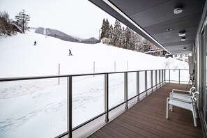 Enjoy breathtaking views of the ski slope from this cozy balcony.