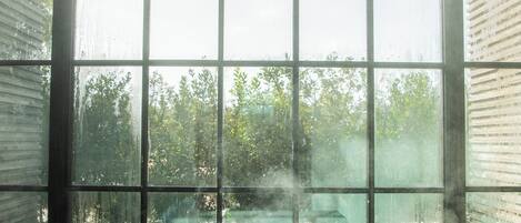 A room with a large window, a radiator, and a reflective floor.