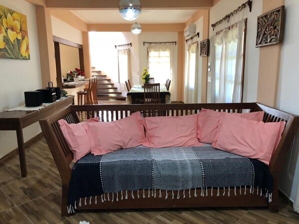 Una sala de estar acogedora con un sofá, una mesa de centro de madera y una zona de comedor con una mesa y sillas.