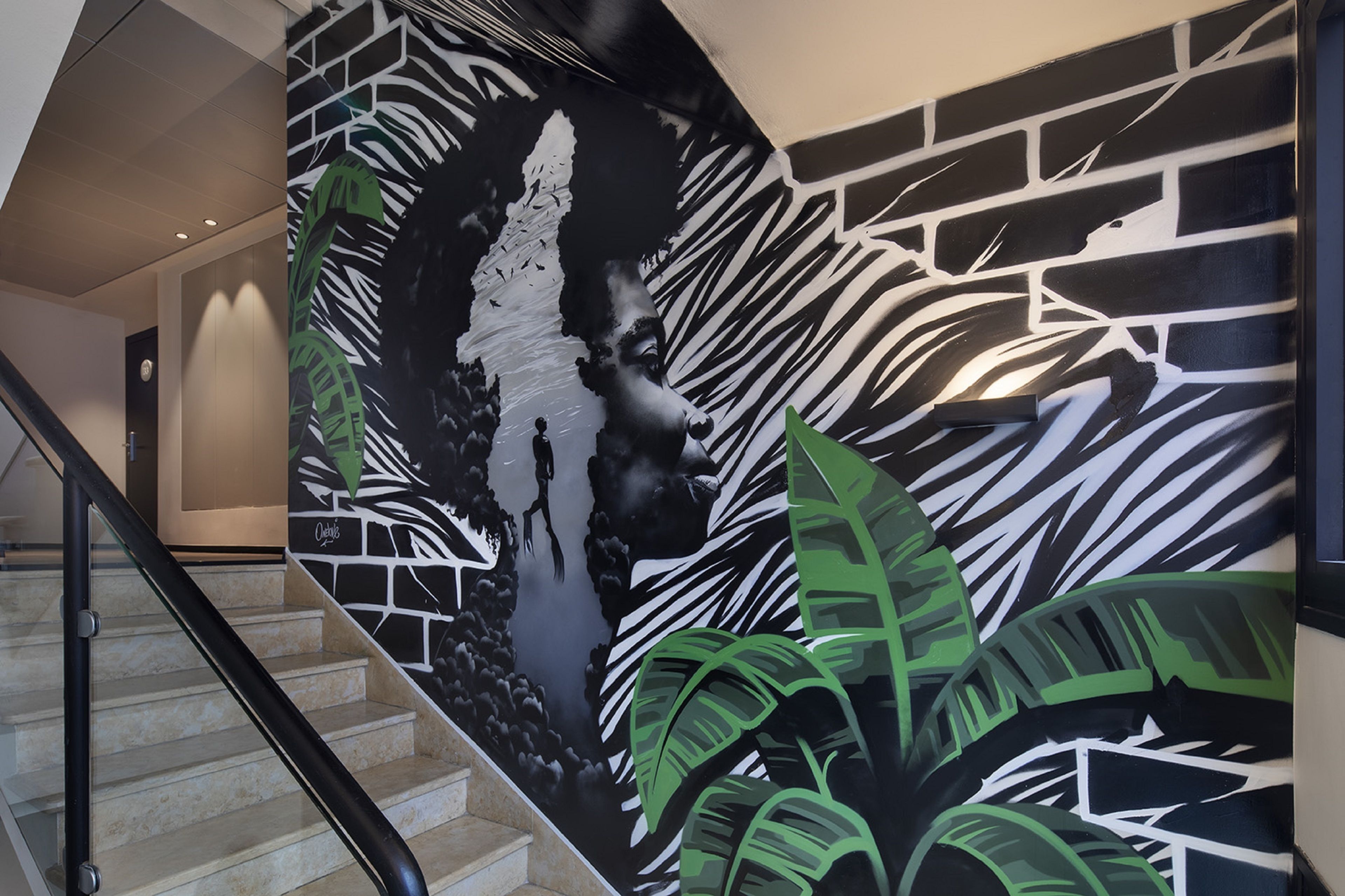 Un escalier orné d’une fresque représentant un zèbre et un lion.