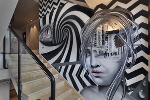 Una escalera con un mural blanco y negro de diseño.