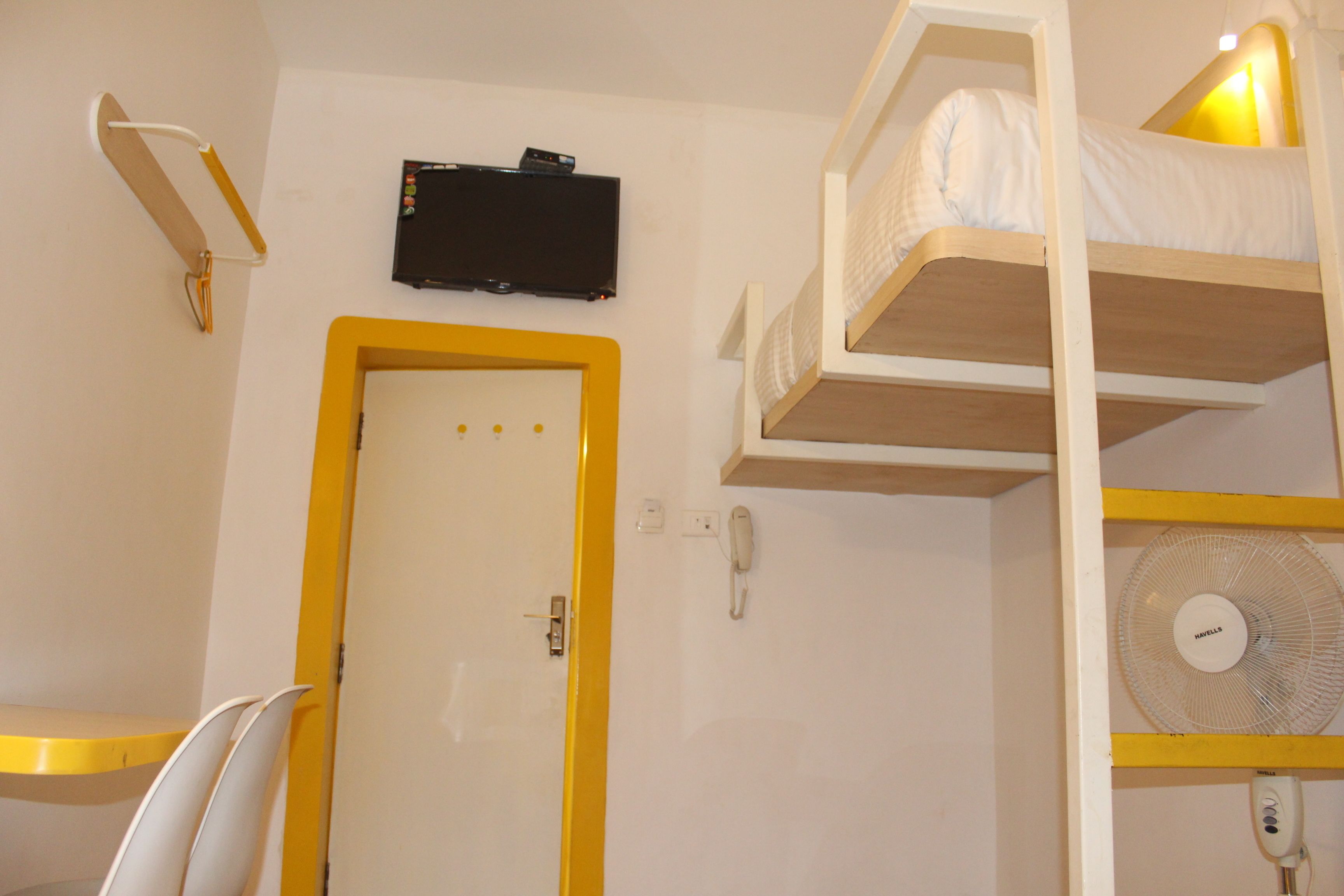 Ein Stockbett mit Ventilator und einem an der Wand montierten Fernseher.