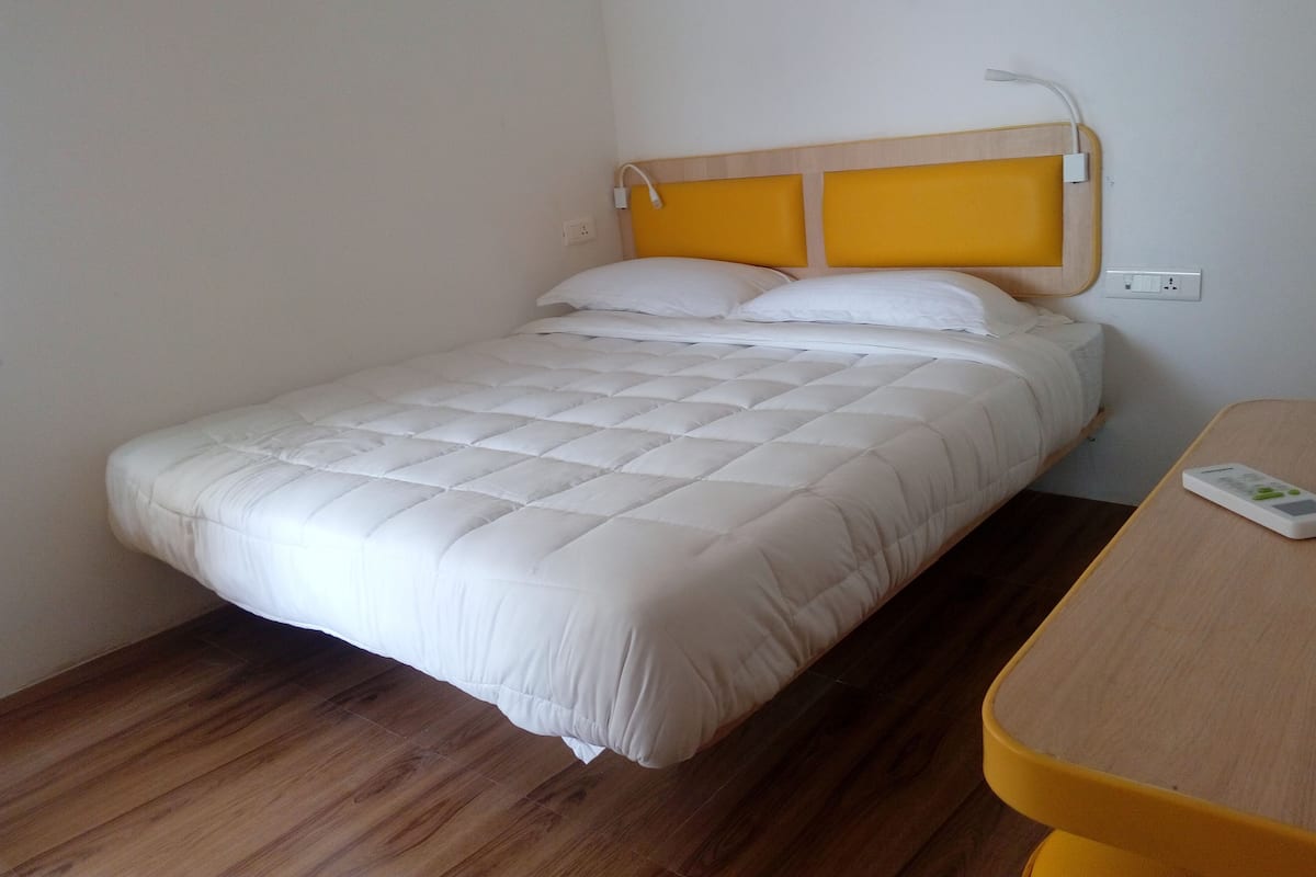 Un letto singolo con una testiera in legno e un comodino.
