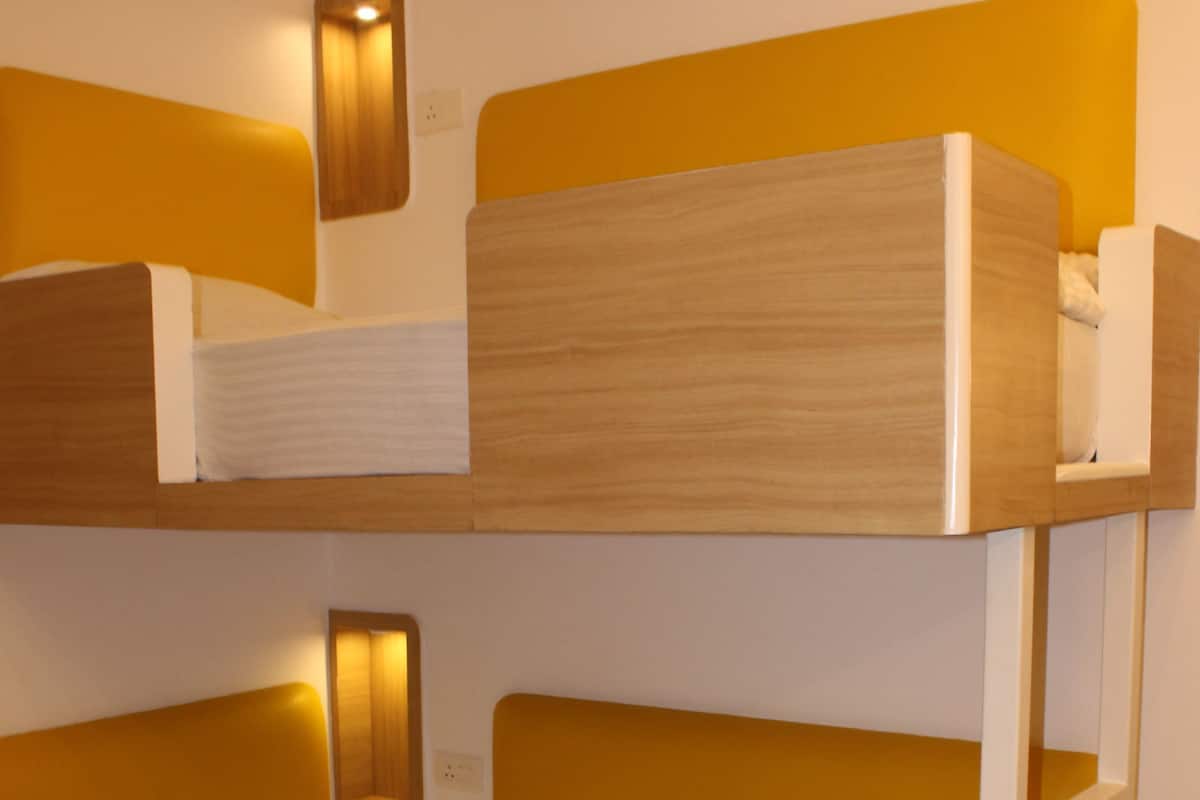 Un letto a castello con struttura in legno e biancheria bianca.