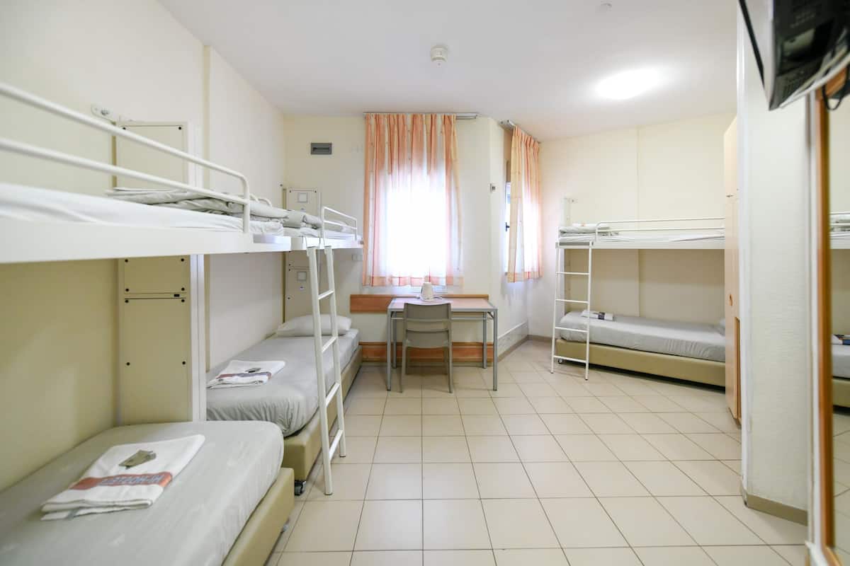 Un dormitorio con literas, un escritorio y una silla.