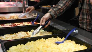 A buffet with various food options, including omelets and scrambled eggs.
