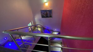 A staircase with metal railings, a wall-mounted light fixture, and a framed picture. - Cosy Park Apartment (Yomra)