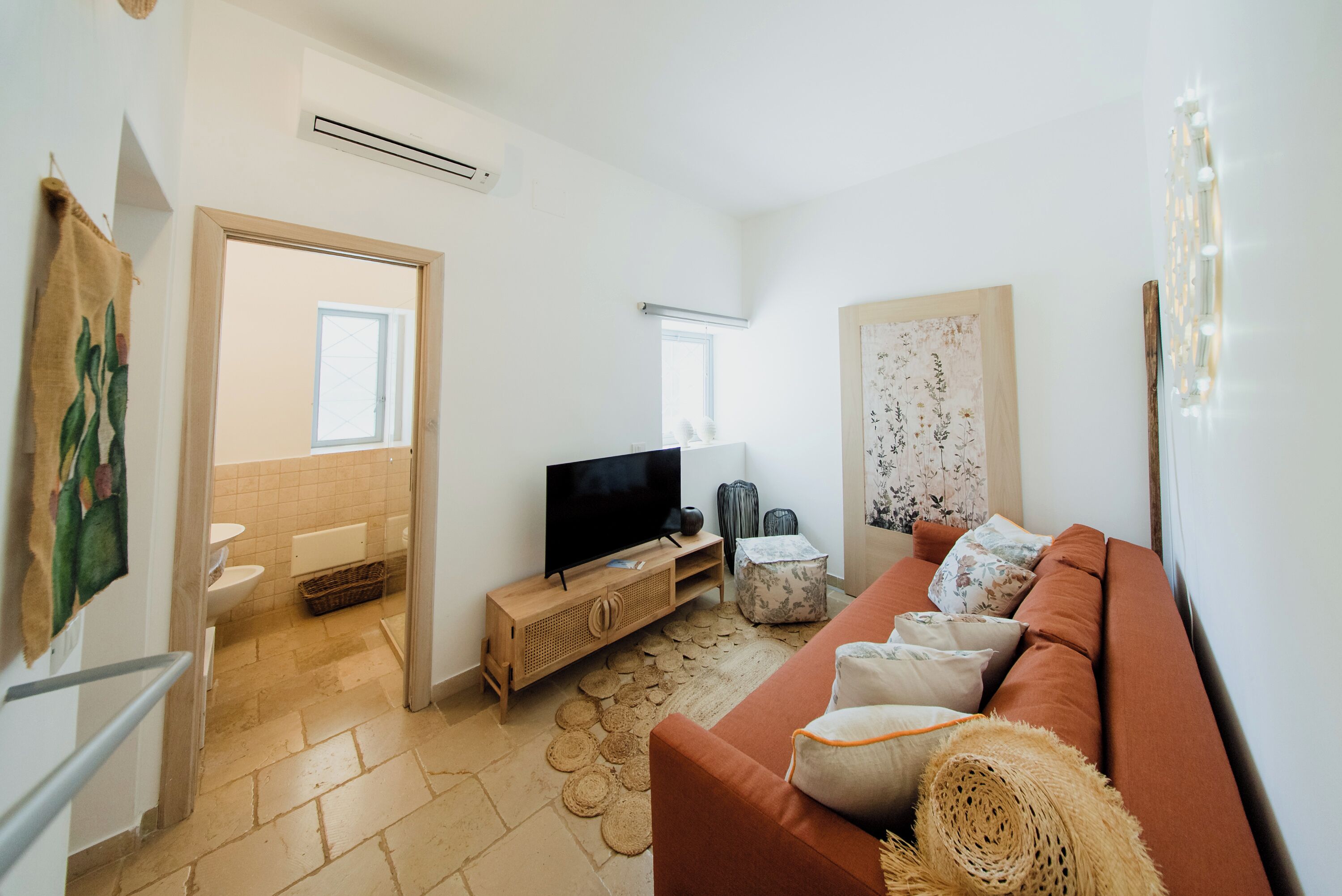 A living room with a sofa, television, and a small table.
