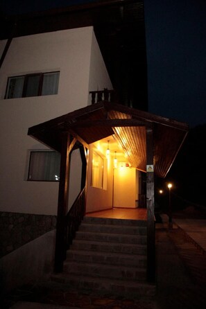 A building with a staircase leading to a covered entrance.