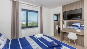 A hotel room with a bed, a TV, a small desk, and a window with curtains. - JAZZ at Rova Apartment Sol (Malinska-Dubasnica)