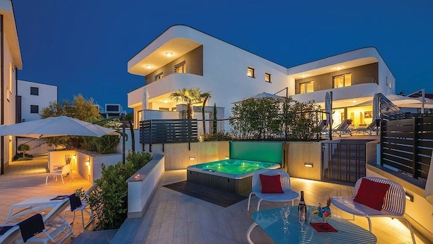 A modern two-story house with a rooftop pool, outdoor seating, and a well-lit patio area. - JAZZ at Rova Apartment Sol (Malinska-Dubasnica)