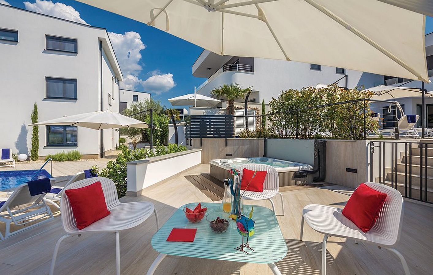 A rooftop terrace with a pool, outdoor seating, and a hot tub.