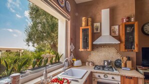A kitchen with a window, sink, stove, and cabinets. - TD Casa Torchiano Hilltop Pool with Sea View (Monopoli)
