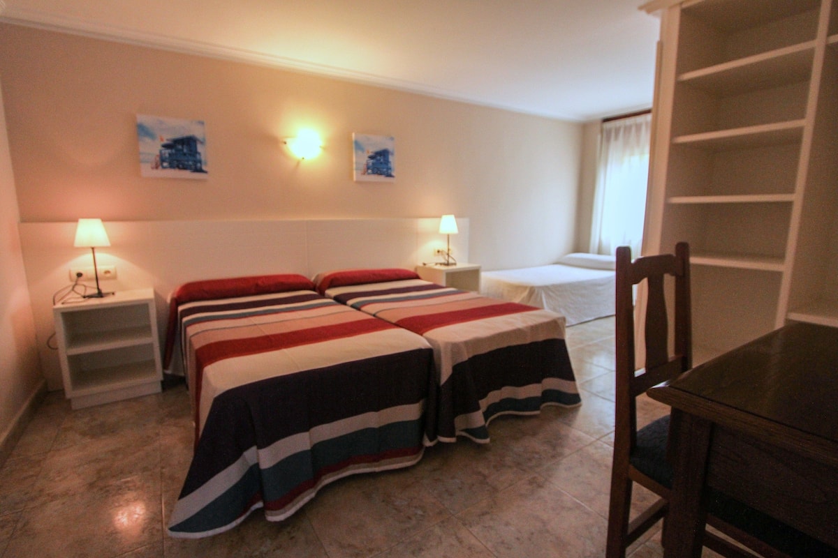 Habitación triple | Escritorio y ropa de cama