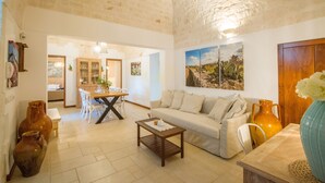 A spacious living room with a sofa, coffee table, and decorative vases. - TD Casale Del Vento in the Countryside with Pool (Monopoli)