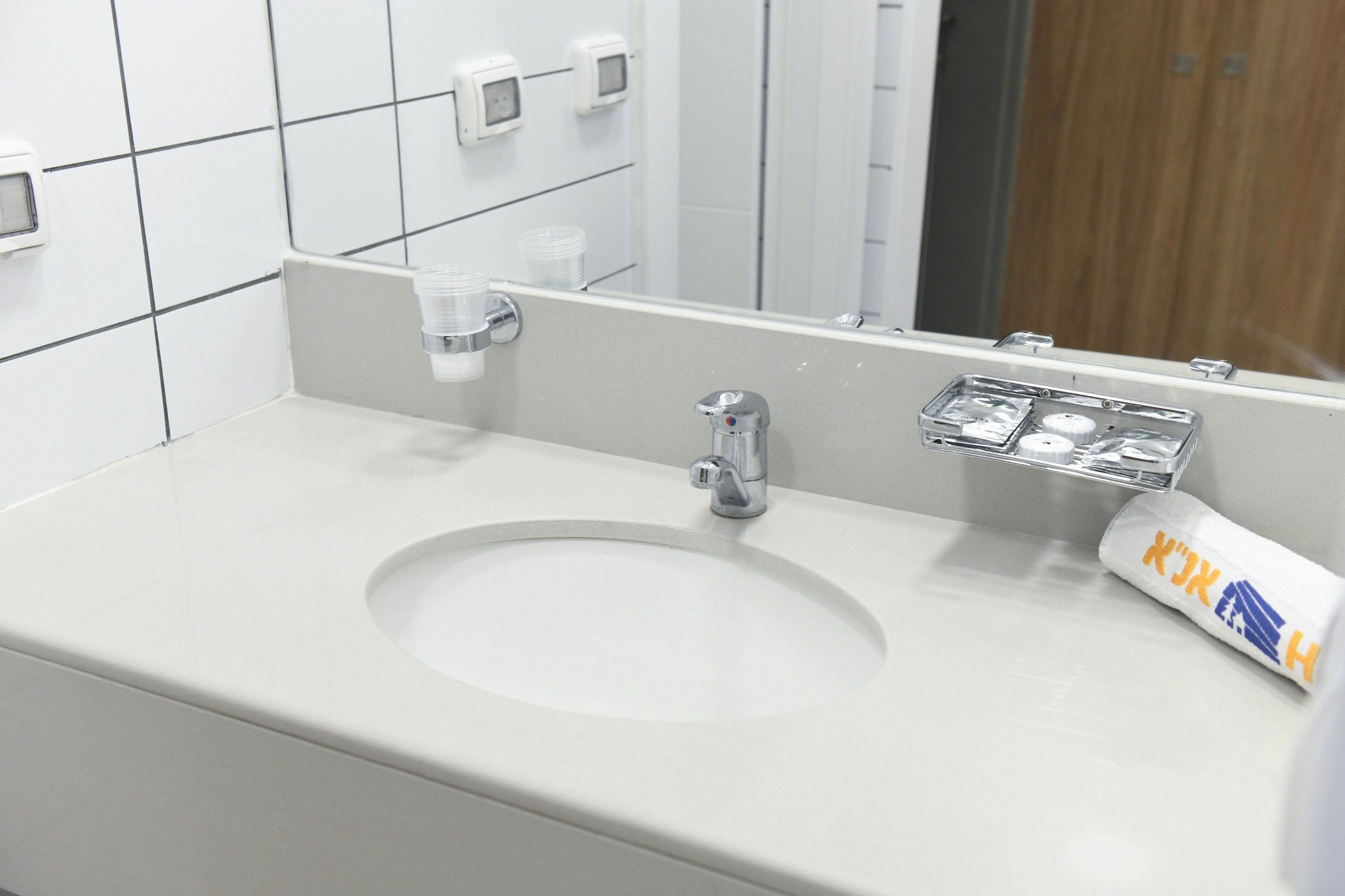 A bathroom sink with a mirror, a faucet, and a soap dispenser.
