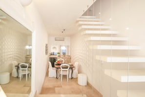 A modern interior with a dining area, kitchen, and staircase.