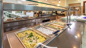 A buffet with various food options, including pasta and eggs, in a well-lit and spacious dining area. - HI Karei Deshe Hostel (Emek HaYarden)