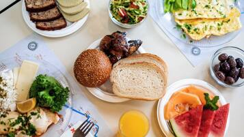Una mesa con diferentes alimentos como pan, un sándwich y una ensalada.
