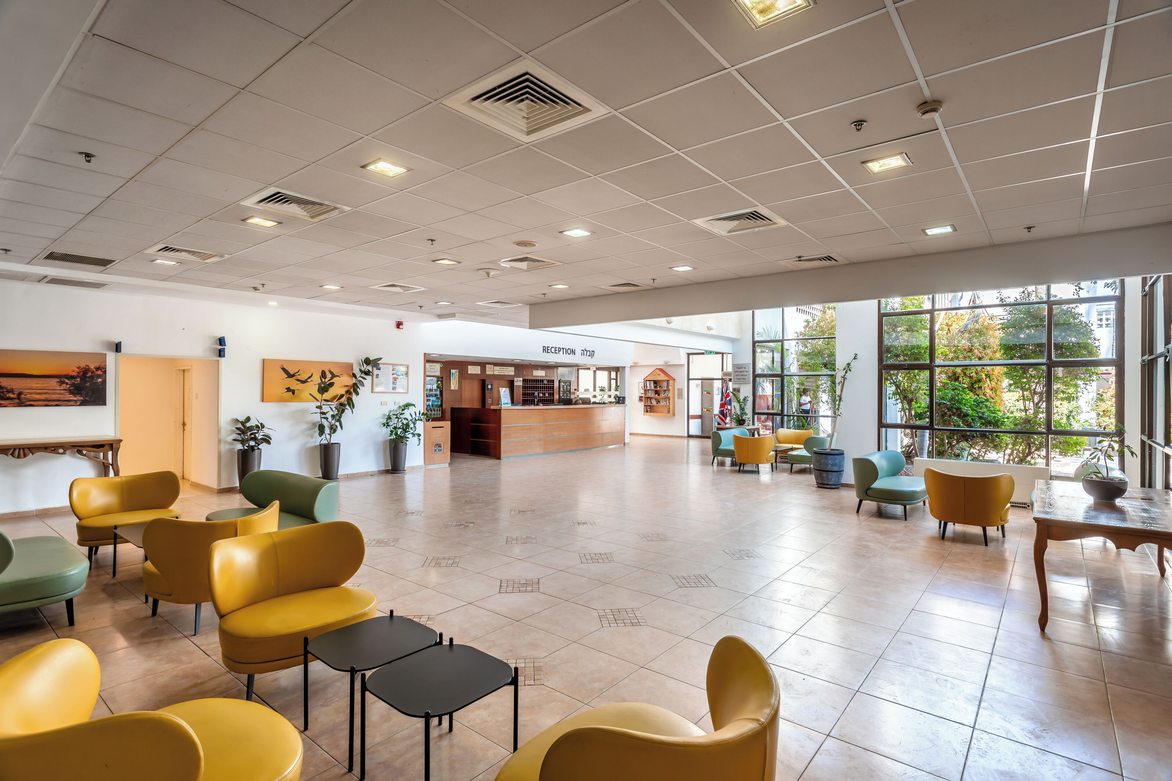 A spacious lobby with a reception desk, seating area, and large windows.