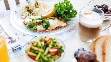 Eine Mahlzeit mit Reis, Salat und einem Getränk auf einem Tisch.