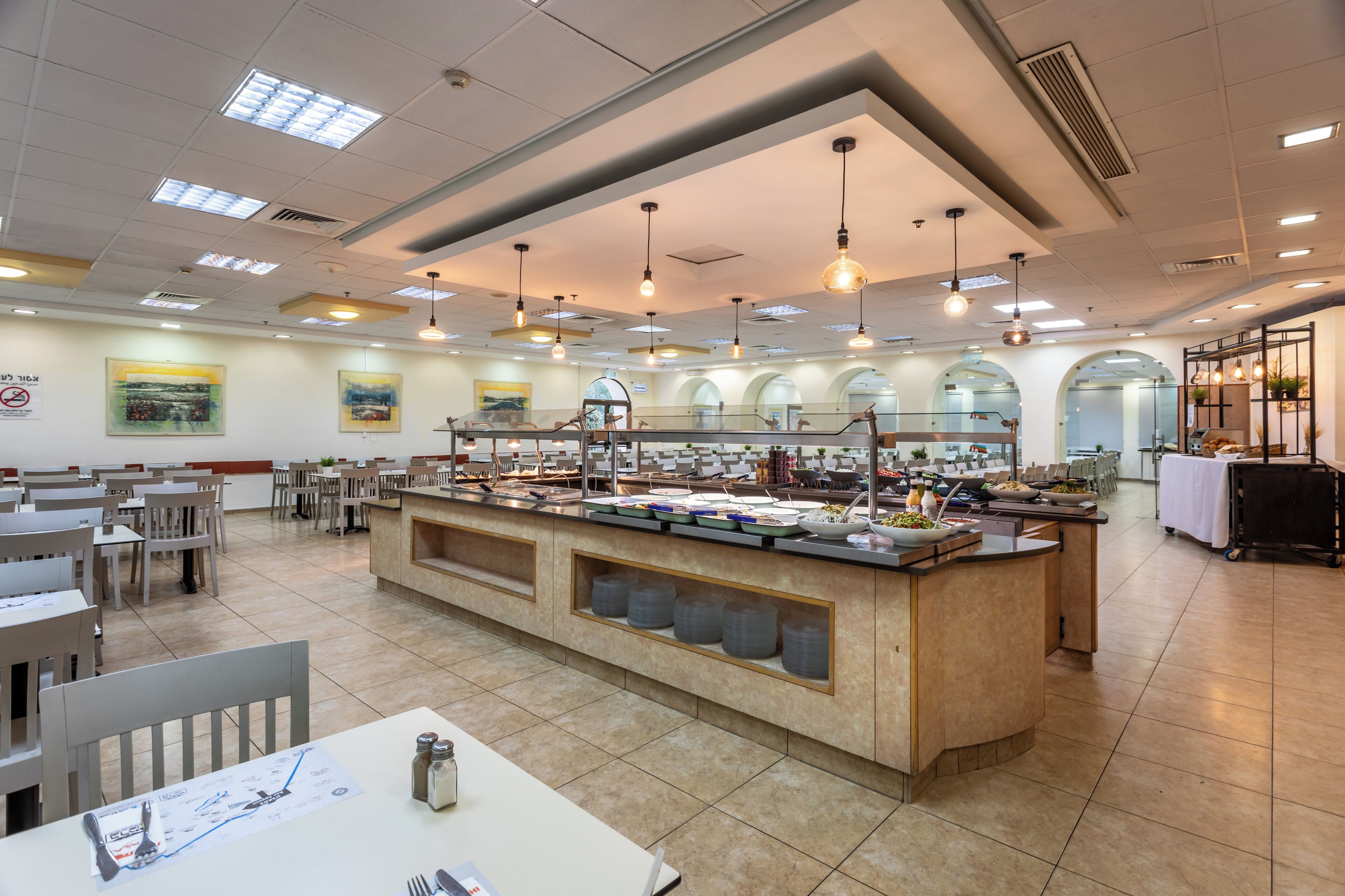 A spacious dining area with multiple tables and a central buffet station.
