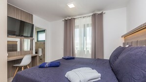 Une chambre d’hôtel avec un lit, un bureau et une télévision.
