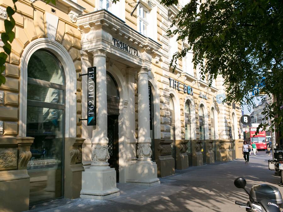 Un edificio histórico con arquitectura clásica, que incluye ventanas en arco y columnas, y un cartel que indica que es un hotel.