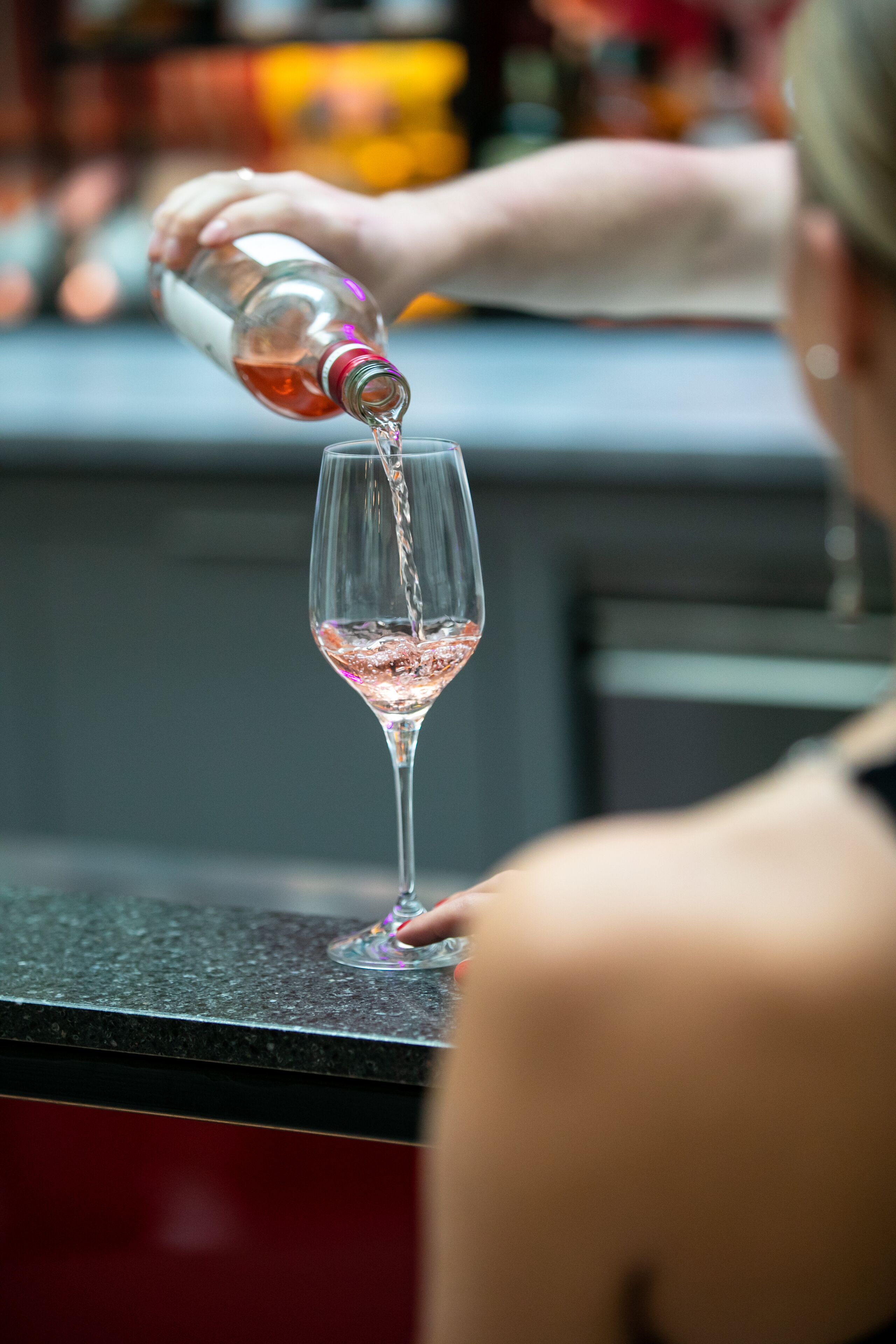 A person pouring a drink into a glass.