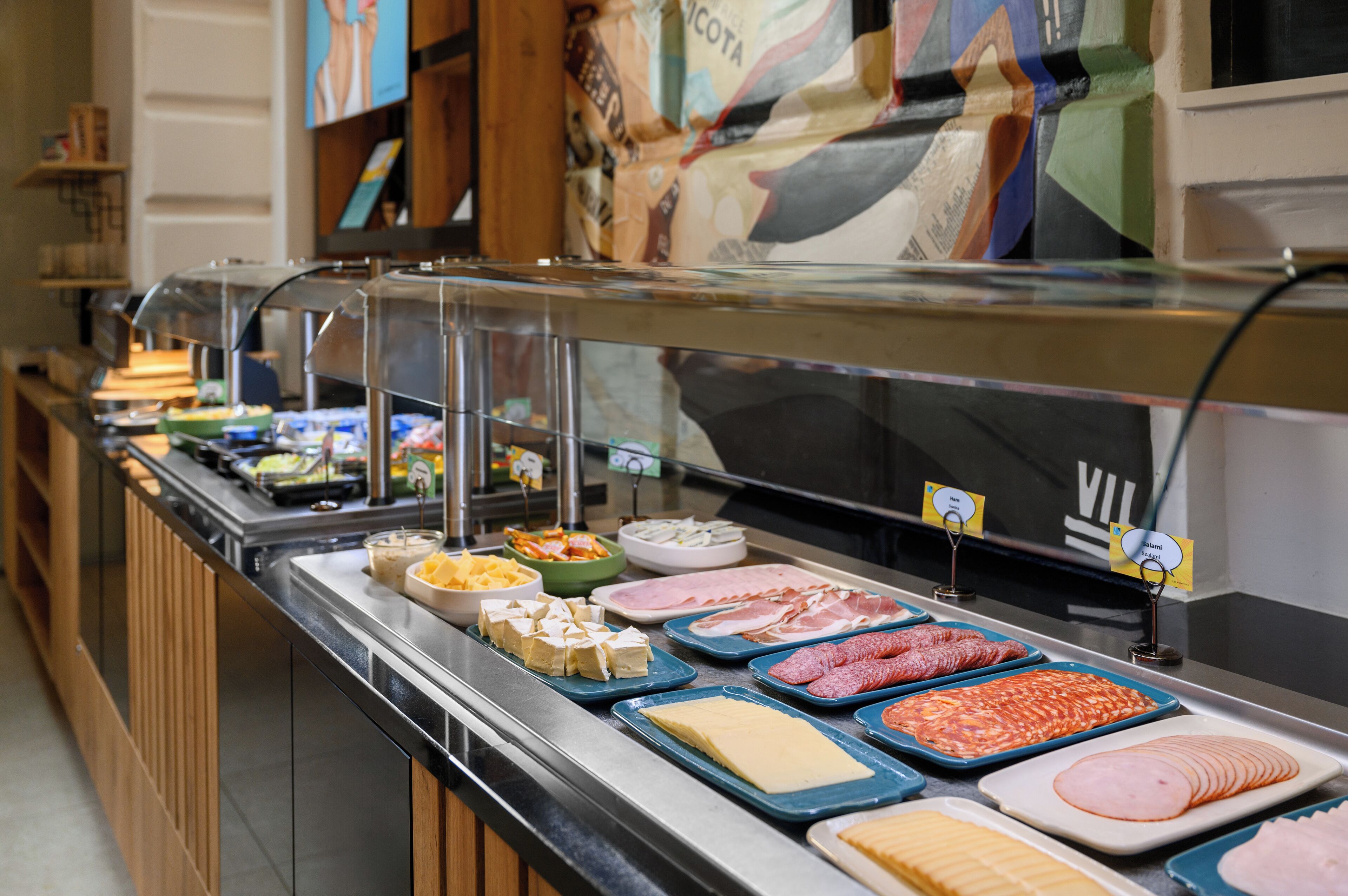 Un buffet proposant une variété de plats, notamment des viandes, des fromages et des salades.