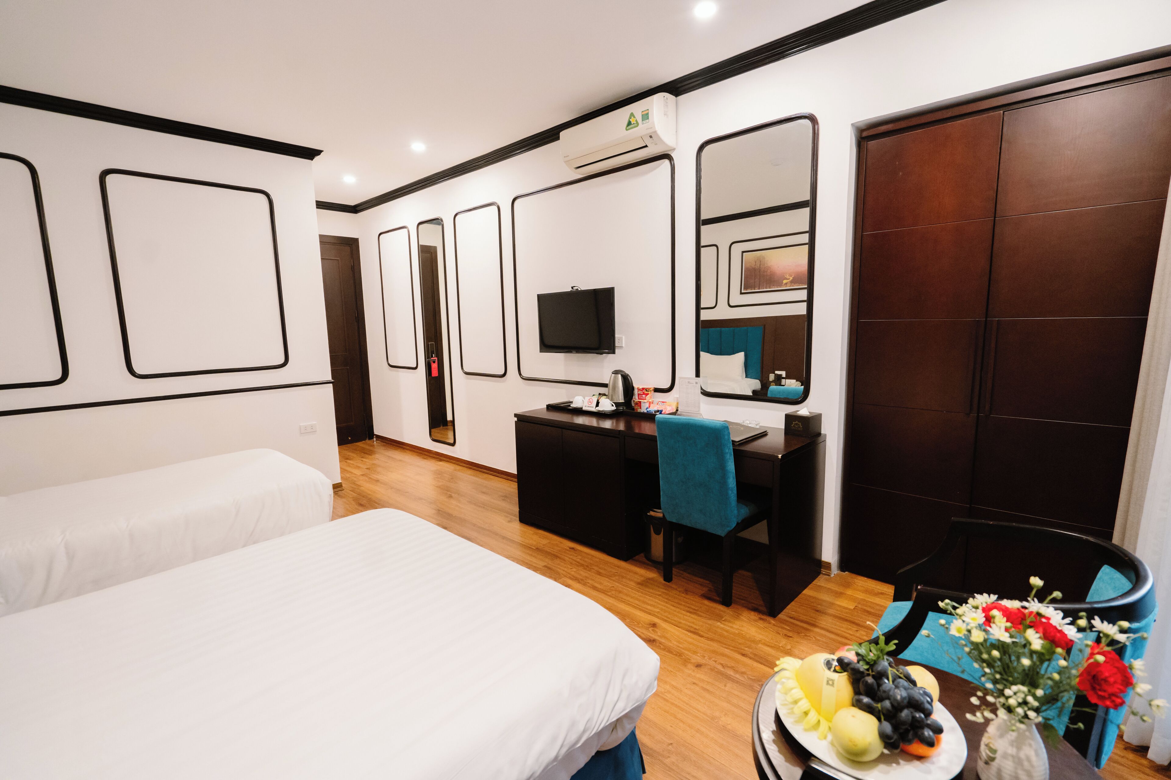 A hotel room with a bed, desk, and wardrobe.
