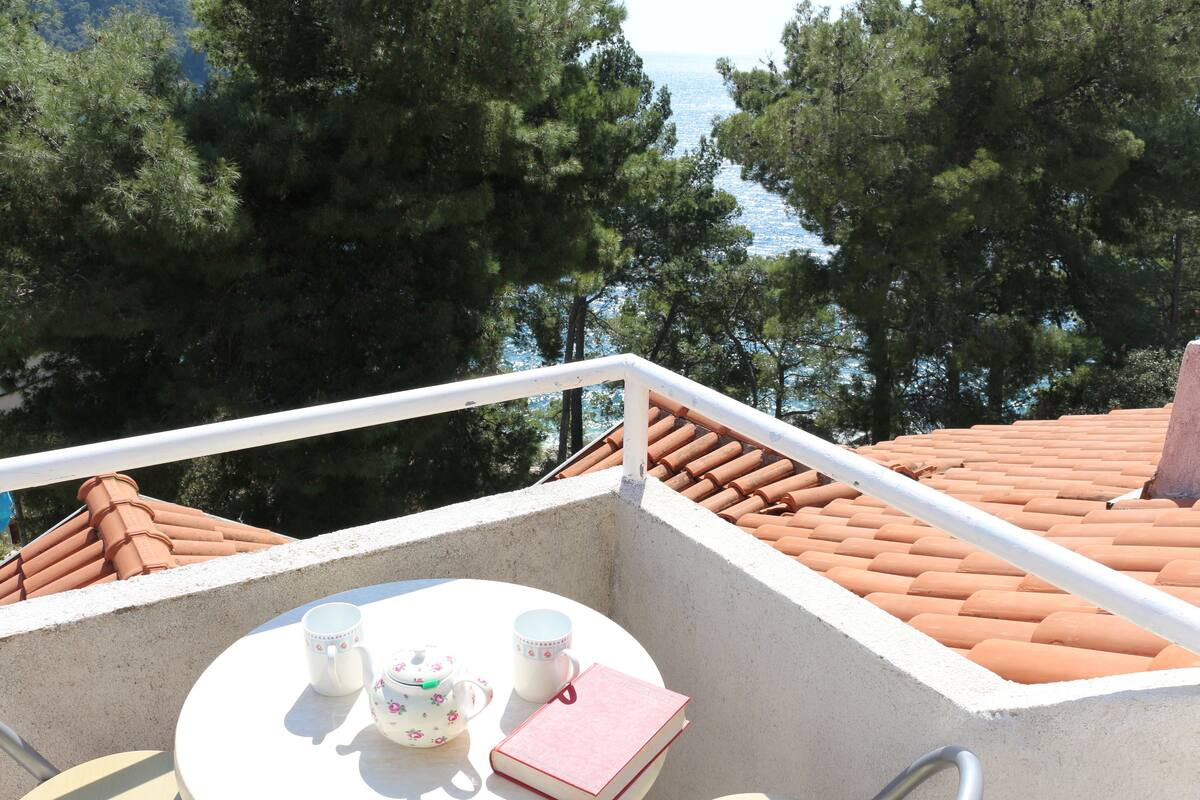 A balcony with a table, two cups, and a book.