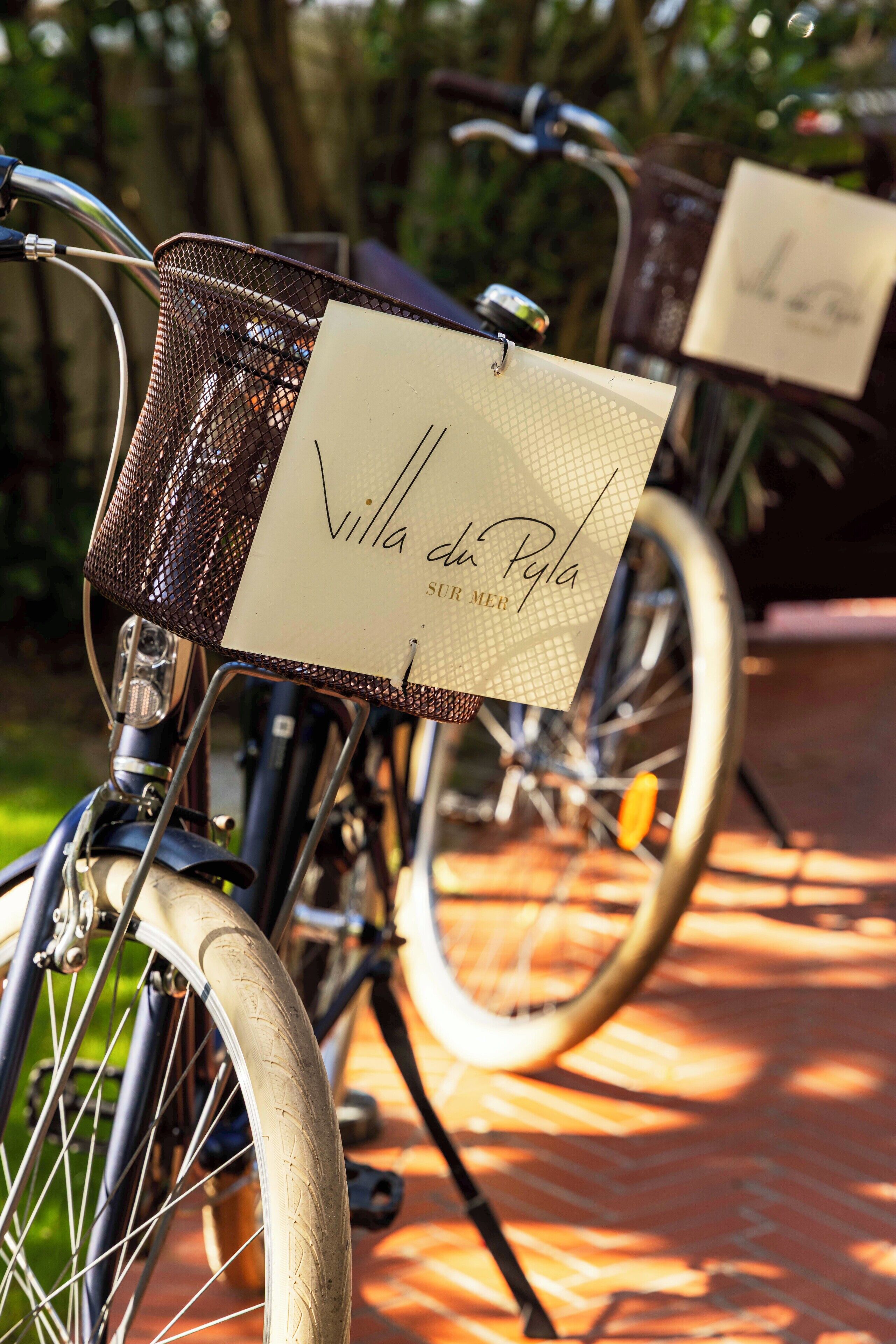 En cykel med en korg och en skylt med texten ”Villa de Pila Sur Mer”.