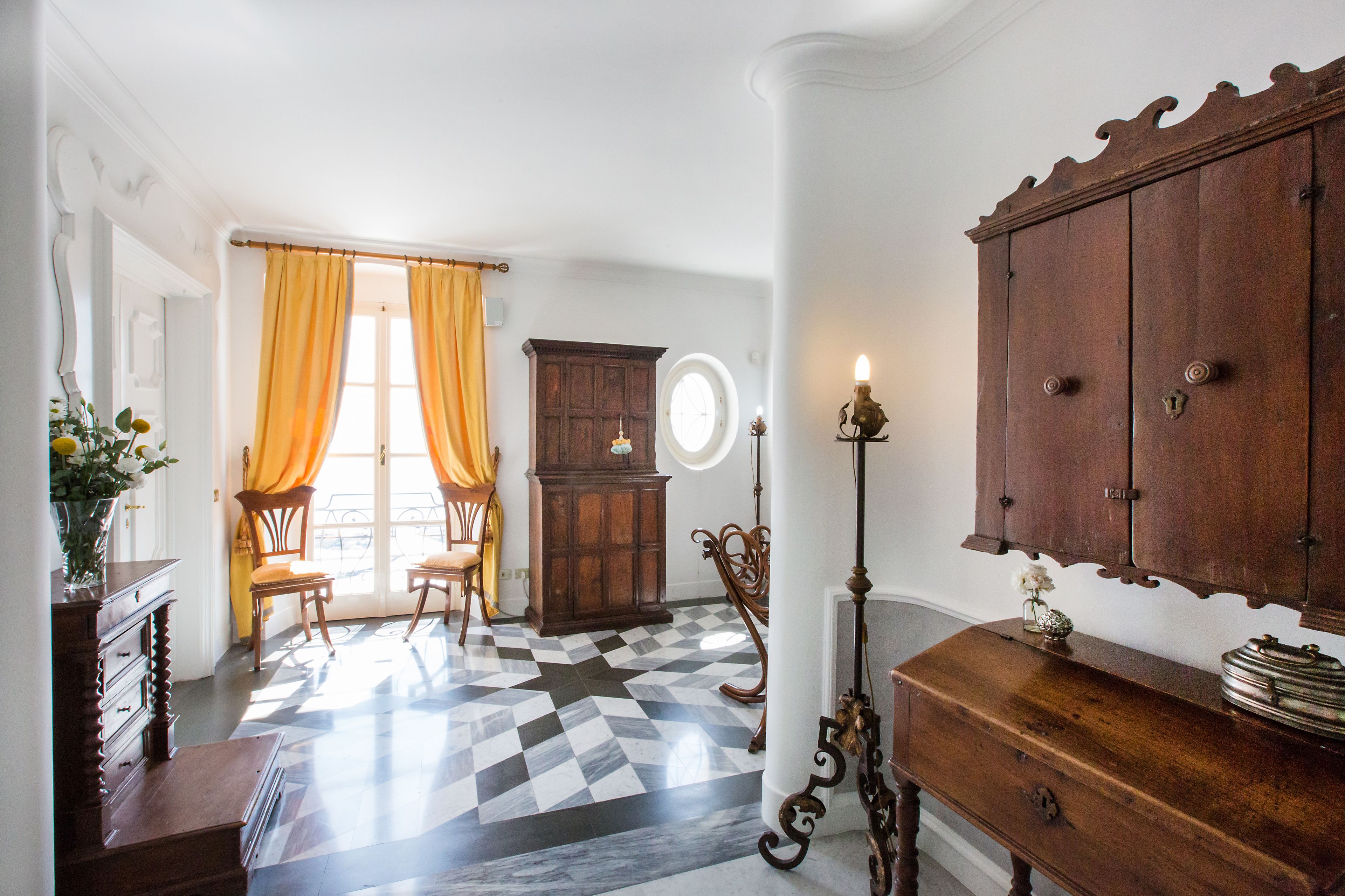 Una habitación con piso a cuadros, un armario de madera, una silla y un escritorio.