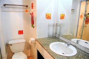 A bathroom with a toilet, sink, and mirror. There are decorative tiles and a towel rack. - View Talay 2 - 1 bed Jomtien (Pattaya)