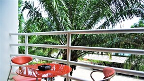 A balcony with a white railing, two red chairs, and a small table with a black object on it. - View Talay 2 - 1 bed Jomtien (Pattaya)