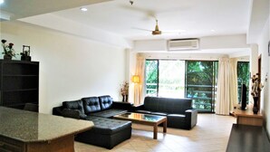 A spacious living room with a sectional sofa, a coffee table, and a TV stand. - View Talay 2 - 1 bed Jomtien (Pattaya)