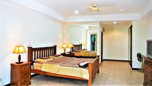 A bedroom with a bed, bedside lamps, a ceiling fan, and a dresser. - View Talay 2 - 1 bed Jomtien (Pattaya)