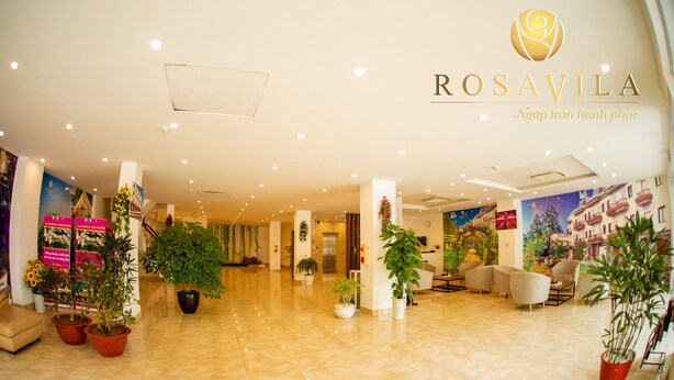 A spacious lobby with a polished marble floor, several potted plants, and a reception area with a large window. - Rosavila (Phan Dinh Phung)
