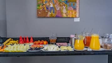 A buffet with various fruits, vegetables, and beverages.