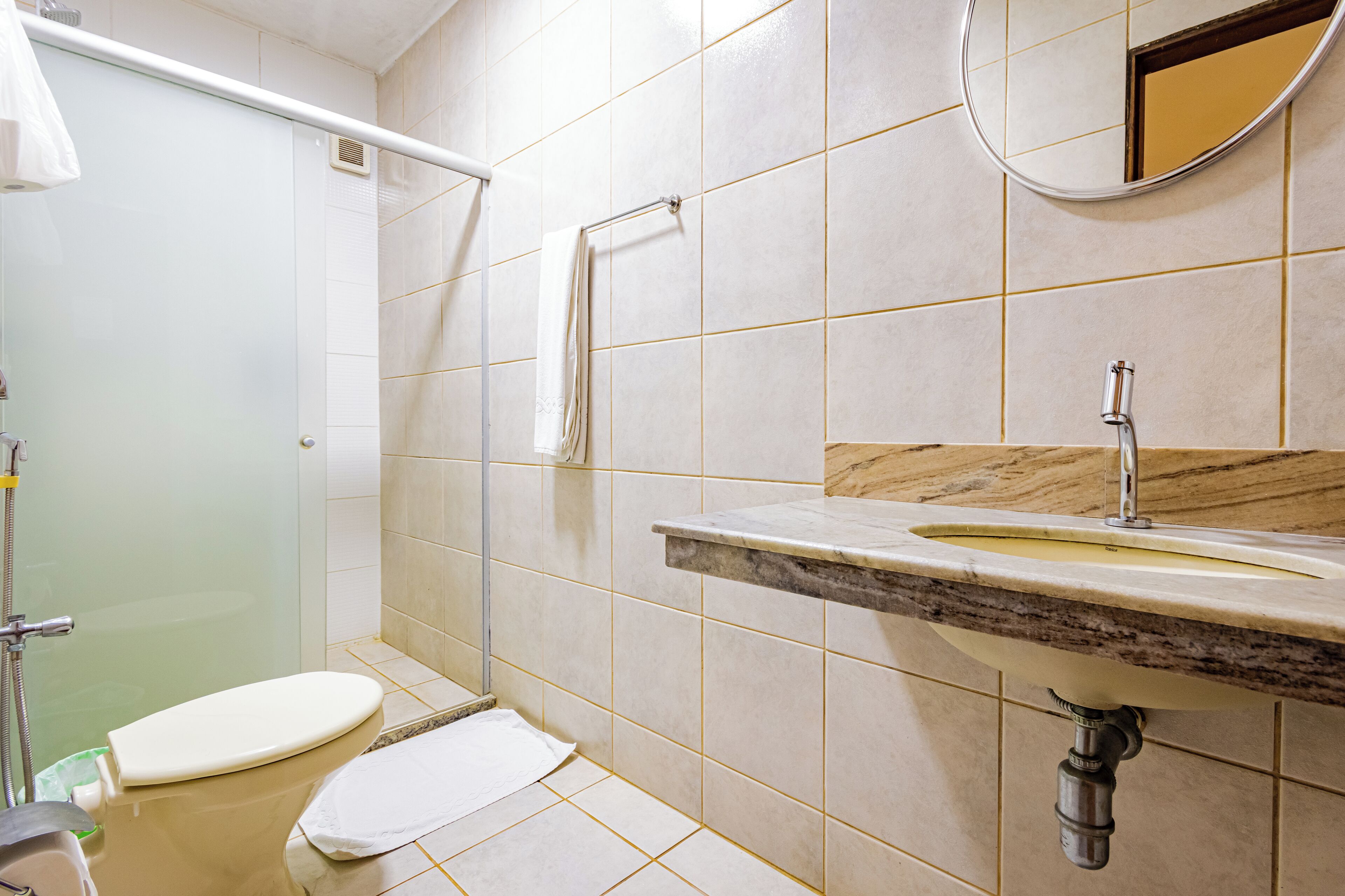 A bathroom with a toilet, sink, and shower.