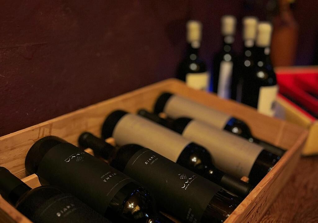 A wooden crate containing several wine bottles.