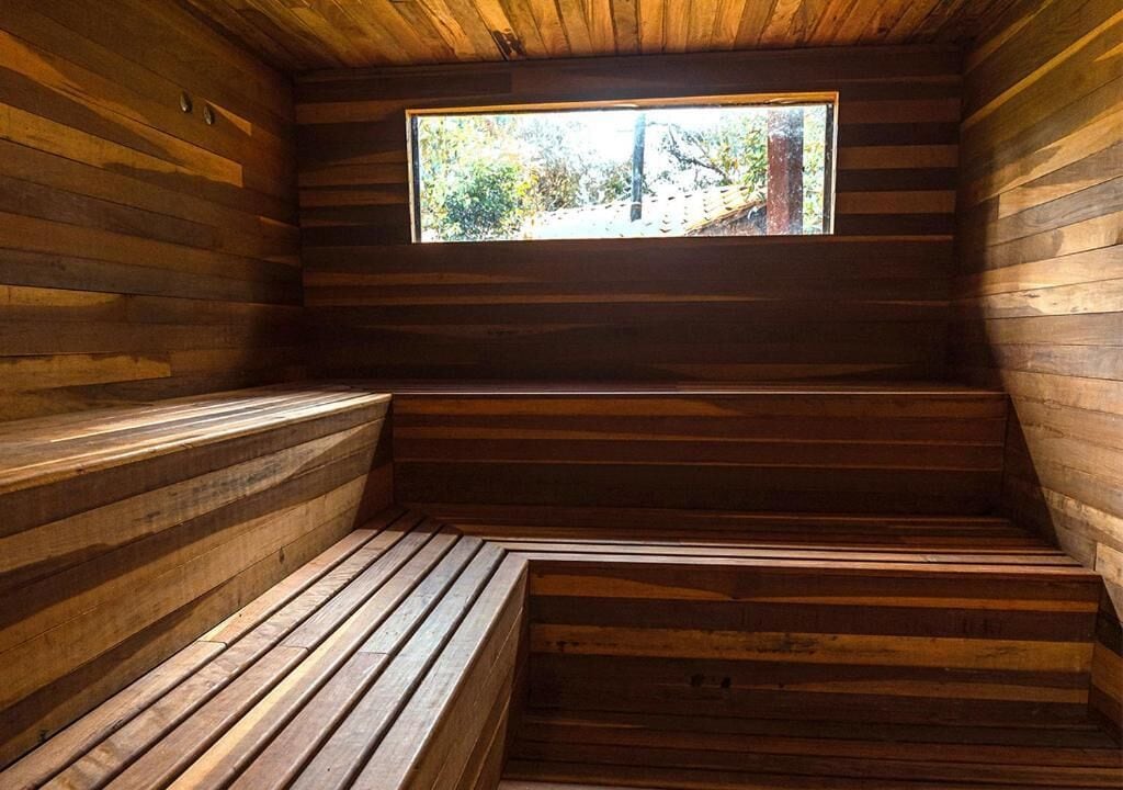 Uma sauna de madeira com bancos e uma janela.