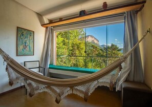 Una hamaca en una habitación con vistas a la montaña y la vegetación.