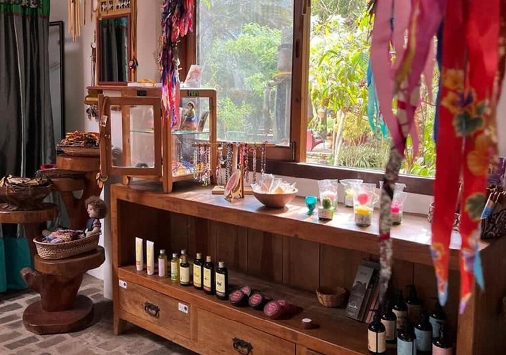 A wooden shelf with various items including bottles, a framed picture, and hanging decorations.