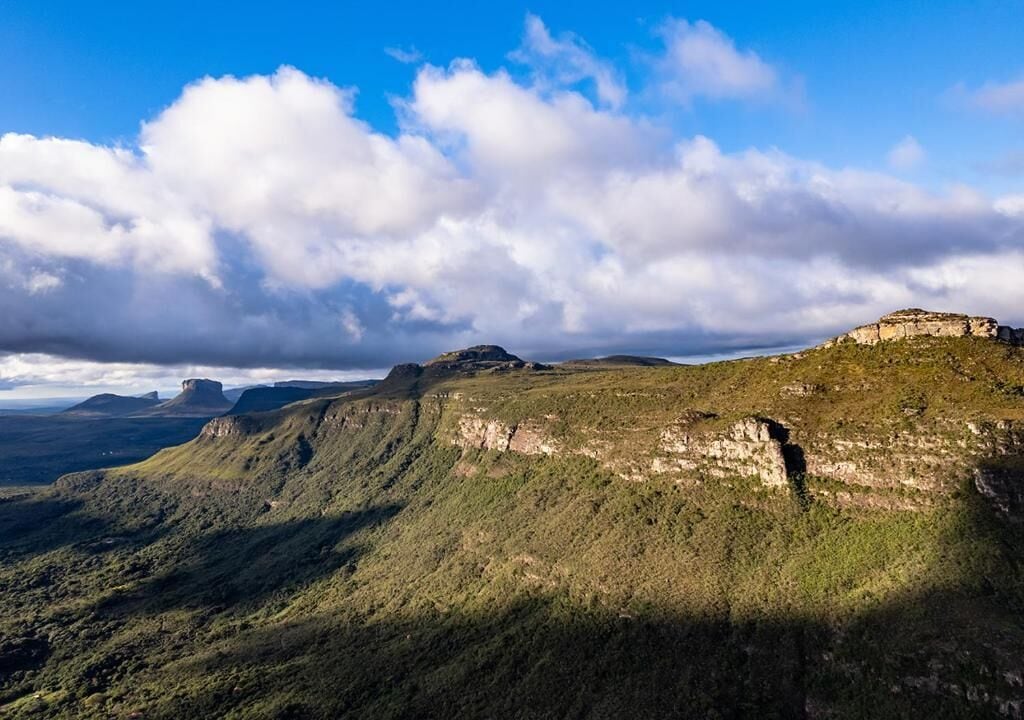 A mountainous landscape with a prominent rock formation and a clear sky.