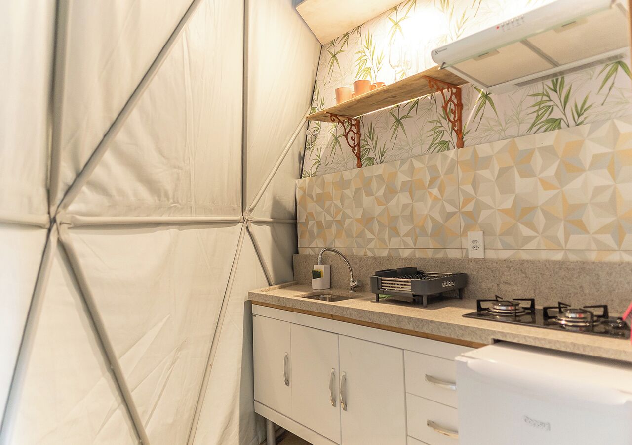 A kitchen with a gas stove, a sink, and a cabinet.