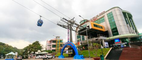 A modern building with a curved facade, a cable car system, and a prominent blue archway.